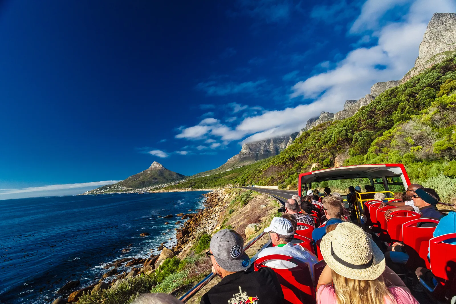 City Sightseeing red open-top bus on a coastal route